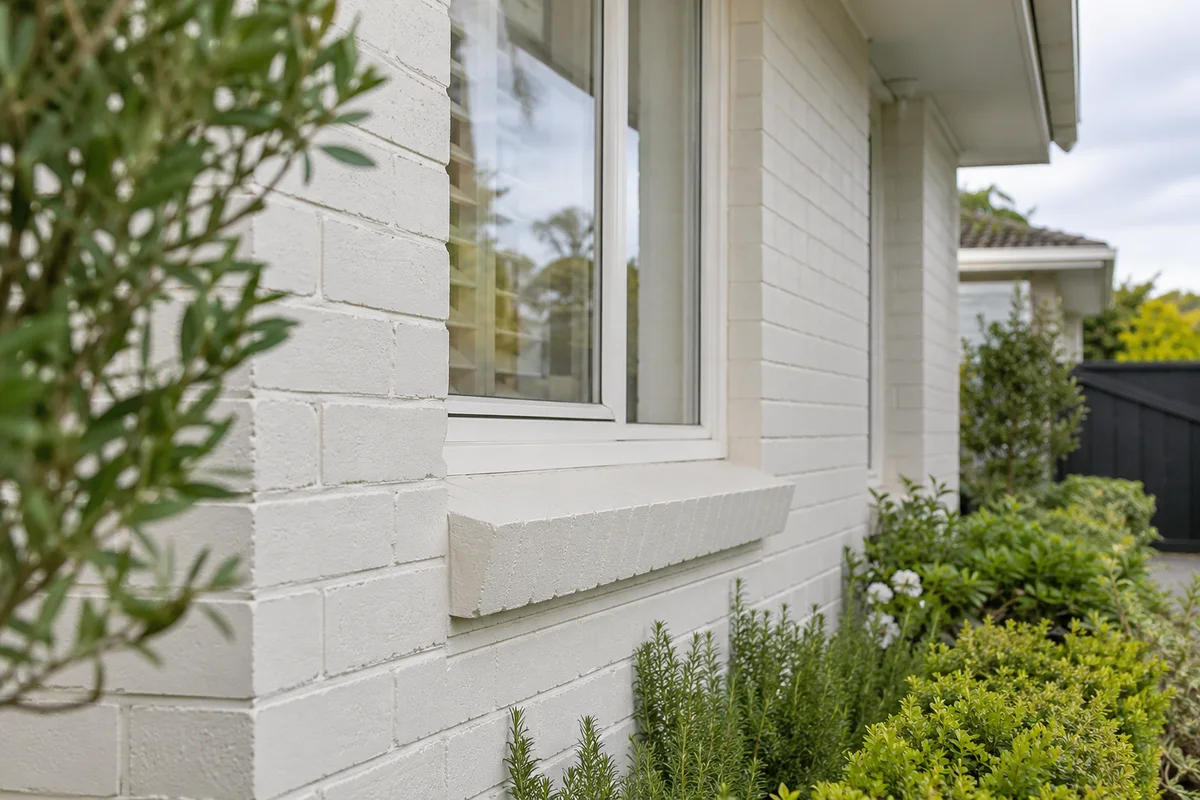 Close view of painted warm white brickwork beside an Auckland home window