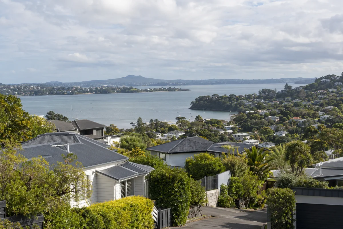 Leafy harbour neighbourhood with residential roofs and low hills